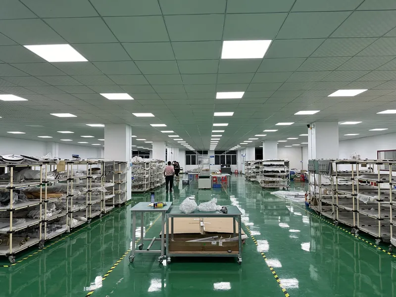 Assembly hall of the CORONA ZHONGSHAN LIGHTING factory with parts racks and workstations